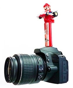Candy dispenser on the hotshoe of a camera.