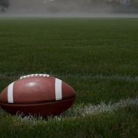 stock photo of a football sitting on a green grass field