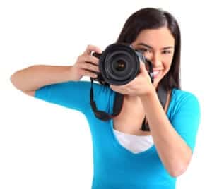 Female young photographer holds a DSLR the wrong way.