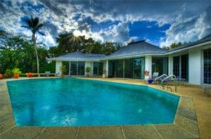 HDR photo of a pool in someone's backyard behind their house in Florida.