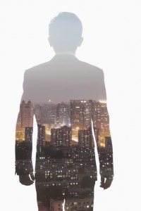 Double exposure of young businessman and the skyline of Shanghai