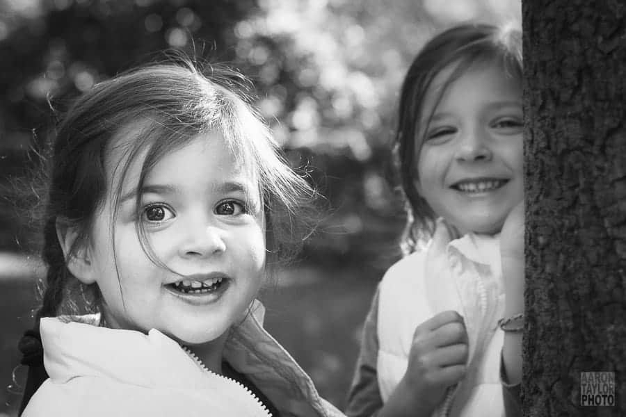 With posing done long ago, I just told these sisters to run around their backyard. They did cartwheels, played tag, and hid behind trees. Chasing them with the camera was a game in itself, a worthwhile game when this great candid shot was captured.