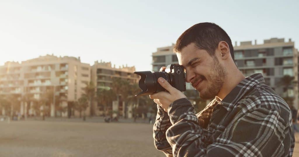 young man taking photos with mirrorless camera