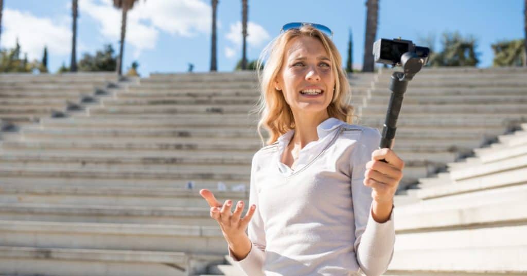 Woman with monopod clicking selfie in park