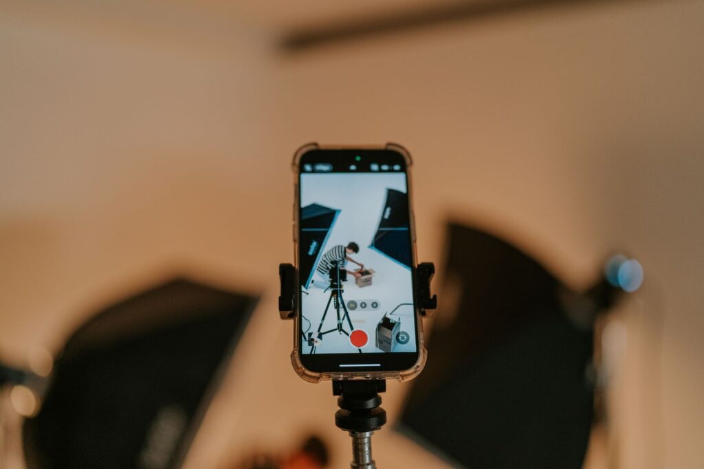 Smartphone on a tripod recording a product video shoot in a studio